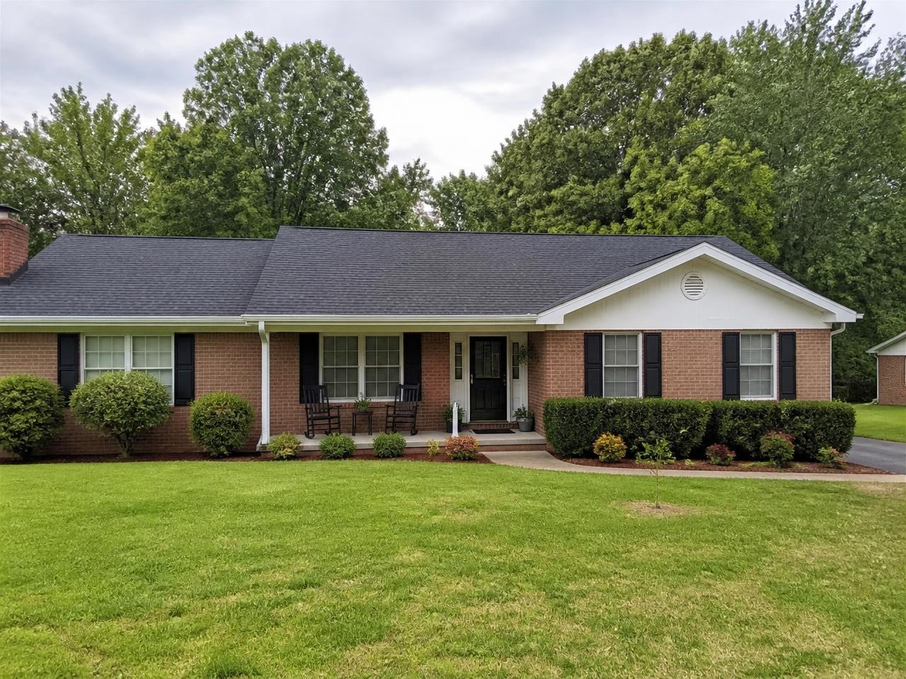 Brick ranch home with a new charcoal shingle roof and white seamless gutters